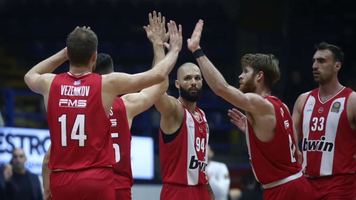 Αθλητές του Ολυμπιακού σε έντονη στιγμή του παιχνιδιού, προετοιμάζονται για μια επικίνδυνη δοκιμασία.